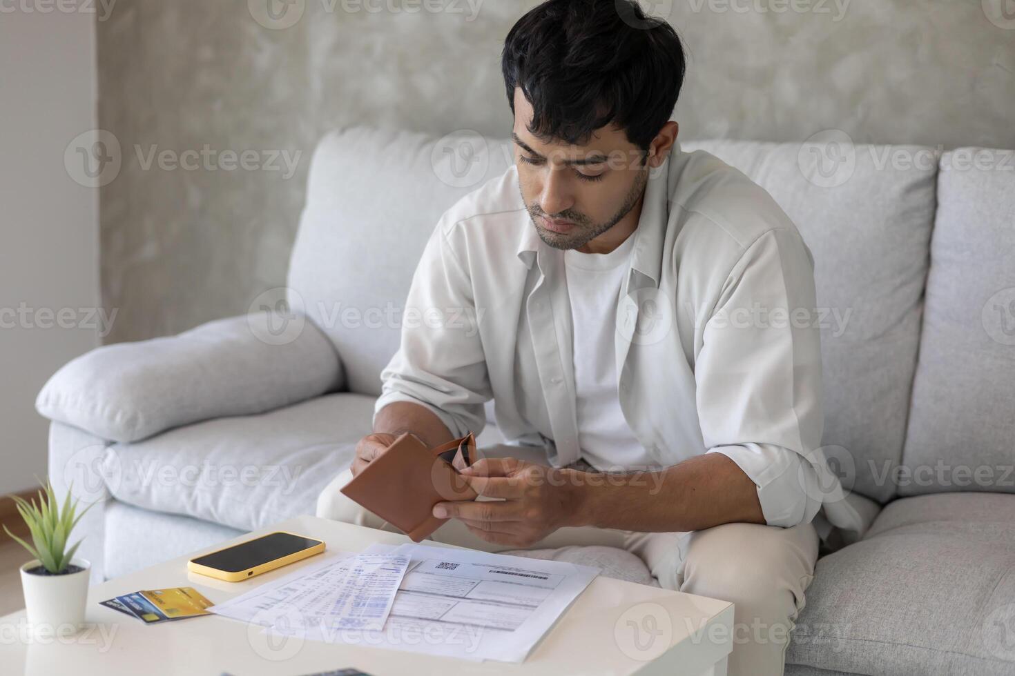 Stressed and headache man with large bills or invoices no money to pay to expenses and credit card debt. shortage, Financial problems, mortgage, loan, bankruptcy, bankrupt, poor, empty wallet photo