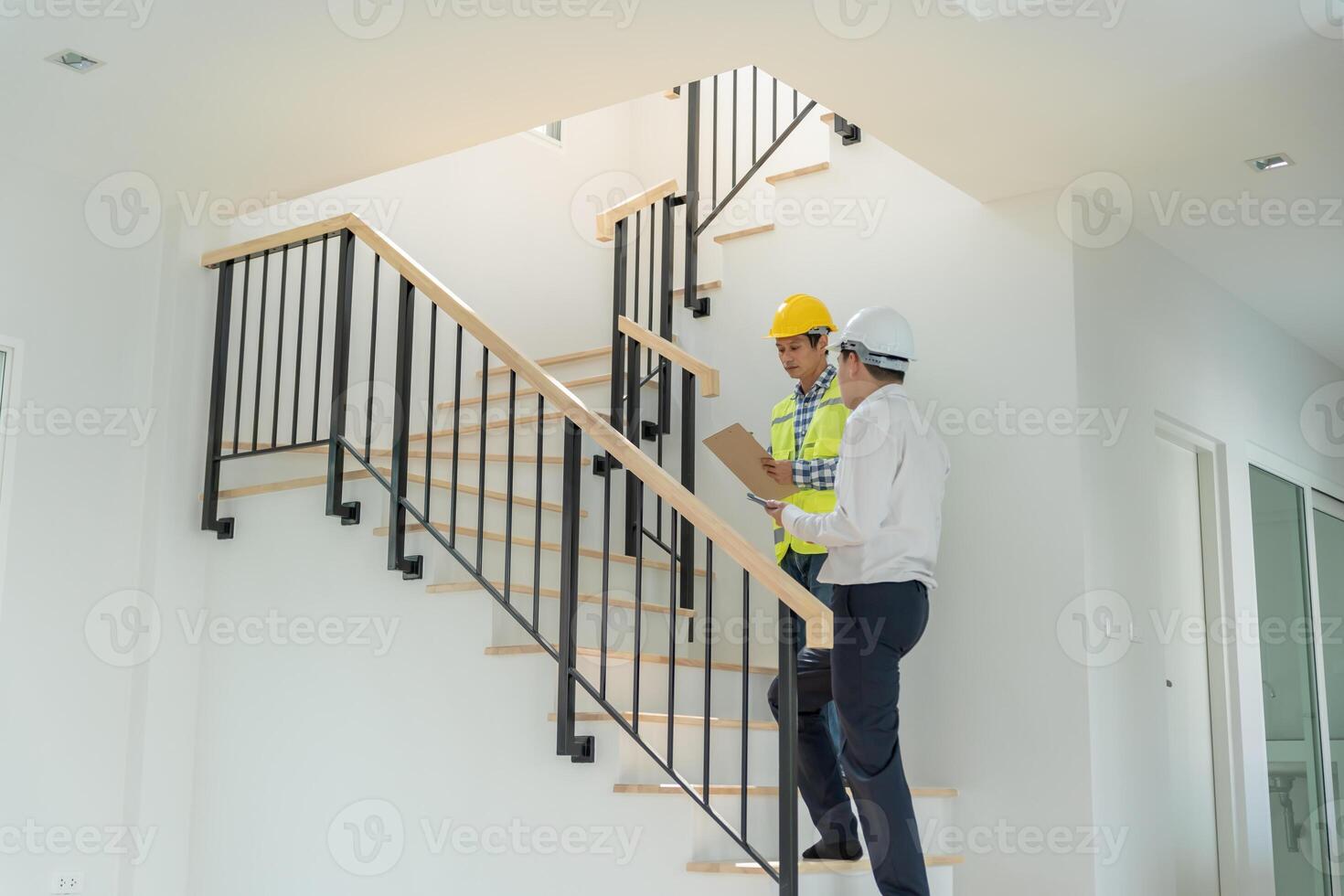 inspector engineer is inspecting construction and quality assurance new house using a tablet. Engineers or architects or contactor work to build the house before handing it over to the homeowner photo
