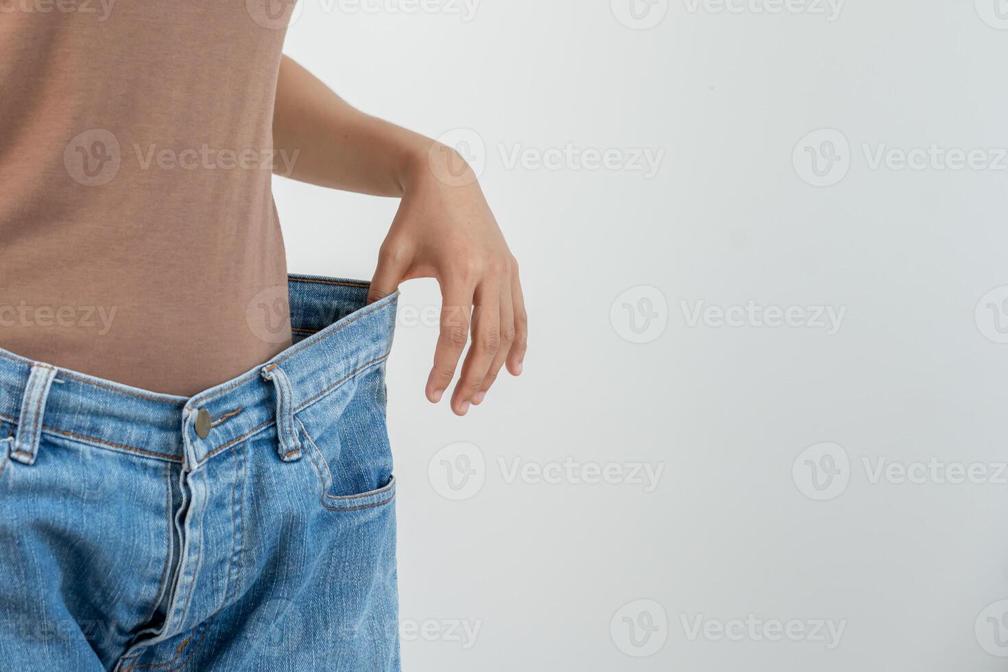 Woman showing results of diet. Beautiful shape. female have a reduced waist size after under going a weight loss corse. can not wear jeans due to weight loss. balance, control, routines, exercise photo
