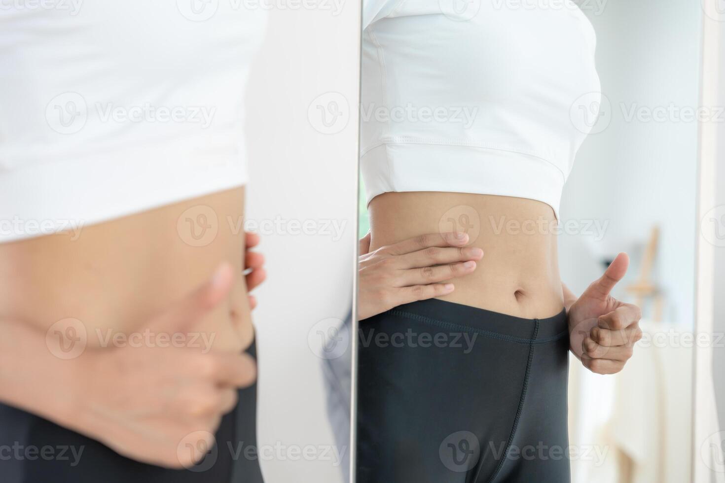 Women showing results of diet. Beautiful shape. female look mirror for check shape body have a reduced waist size after under going a weight loss corse. balance, control, routines, exercise, photo