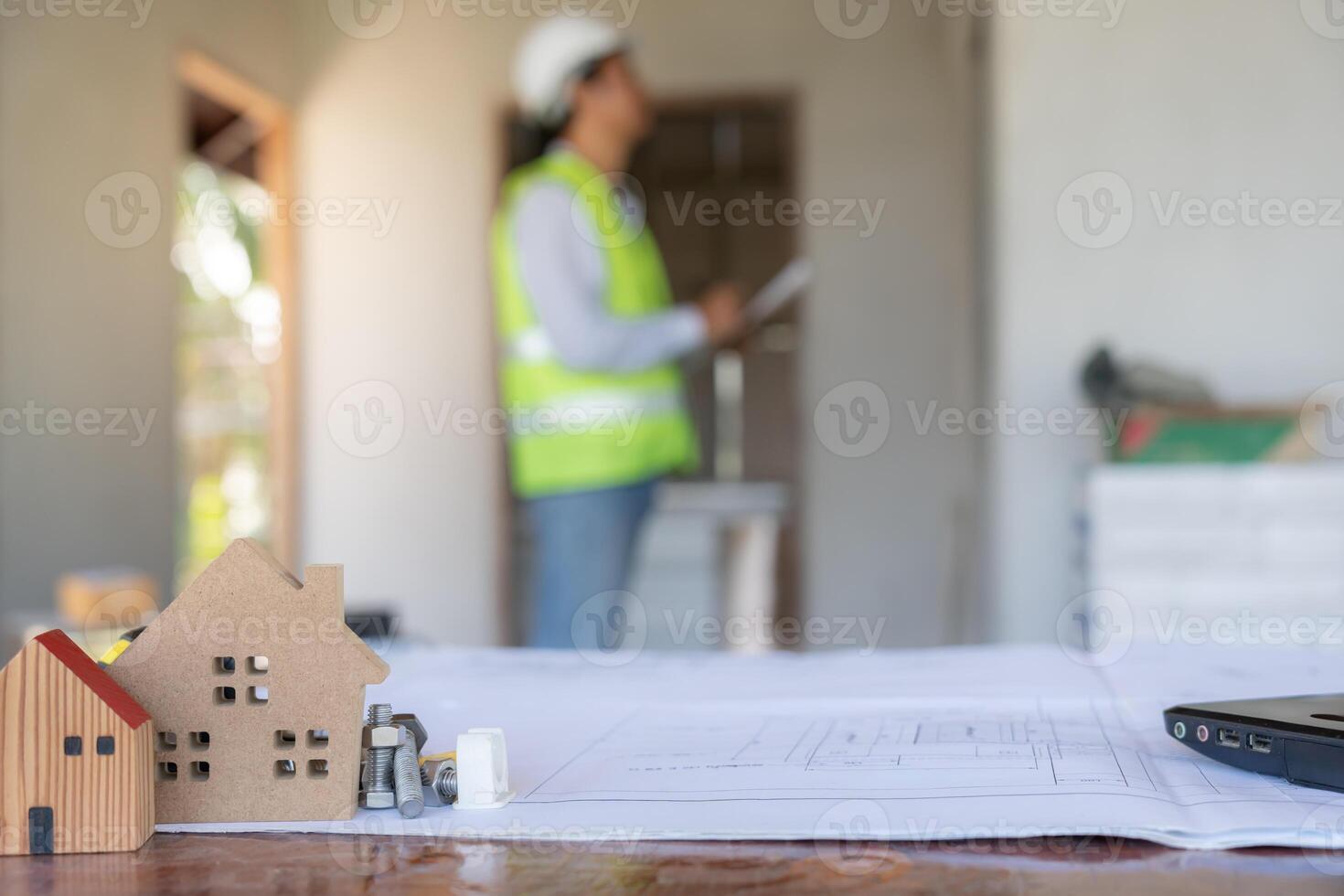 inspector or engineer is inspecting construction and quality assurance new house using a blue print. Engineer or architects or contactor work to build the house before handing photo
