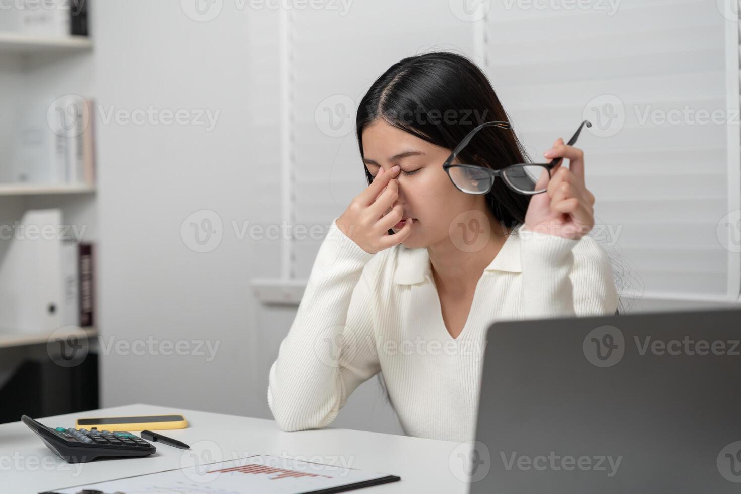 Eye problems, Asian women with tired and irritated eyes, eye rubbing, dry, eye pain after work, migraine, headache, blurred vision, photophobia, working in the dark, blue light from computer screen photo