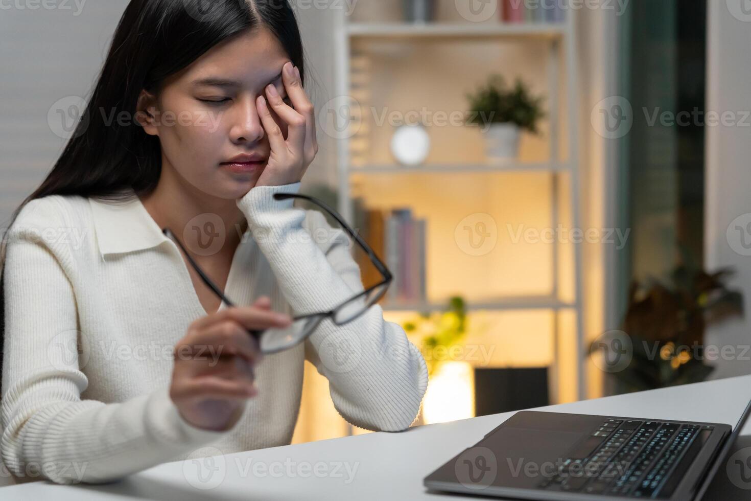Eye problem, Asian women with tired and irritated eyes, eye rubbing, dry, eye pain after work, migraine, headache, blurred vision, photophobia, working in the dark, blue light from computer screens photo