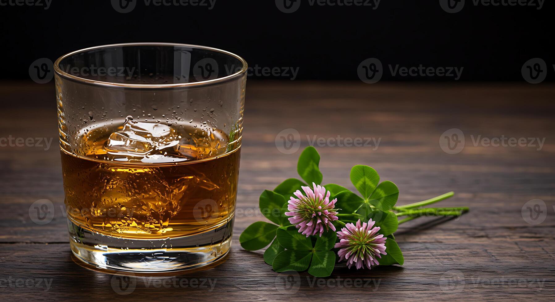Whiskey Glass with Ice and Floral Clover Arrangement on Wooden Surface Close Up photo