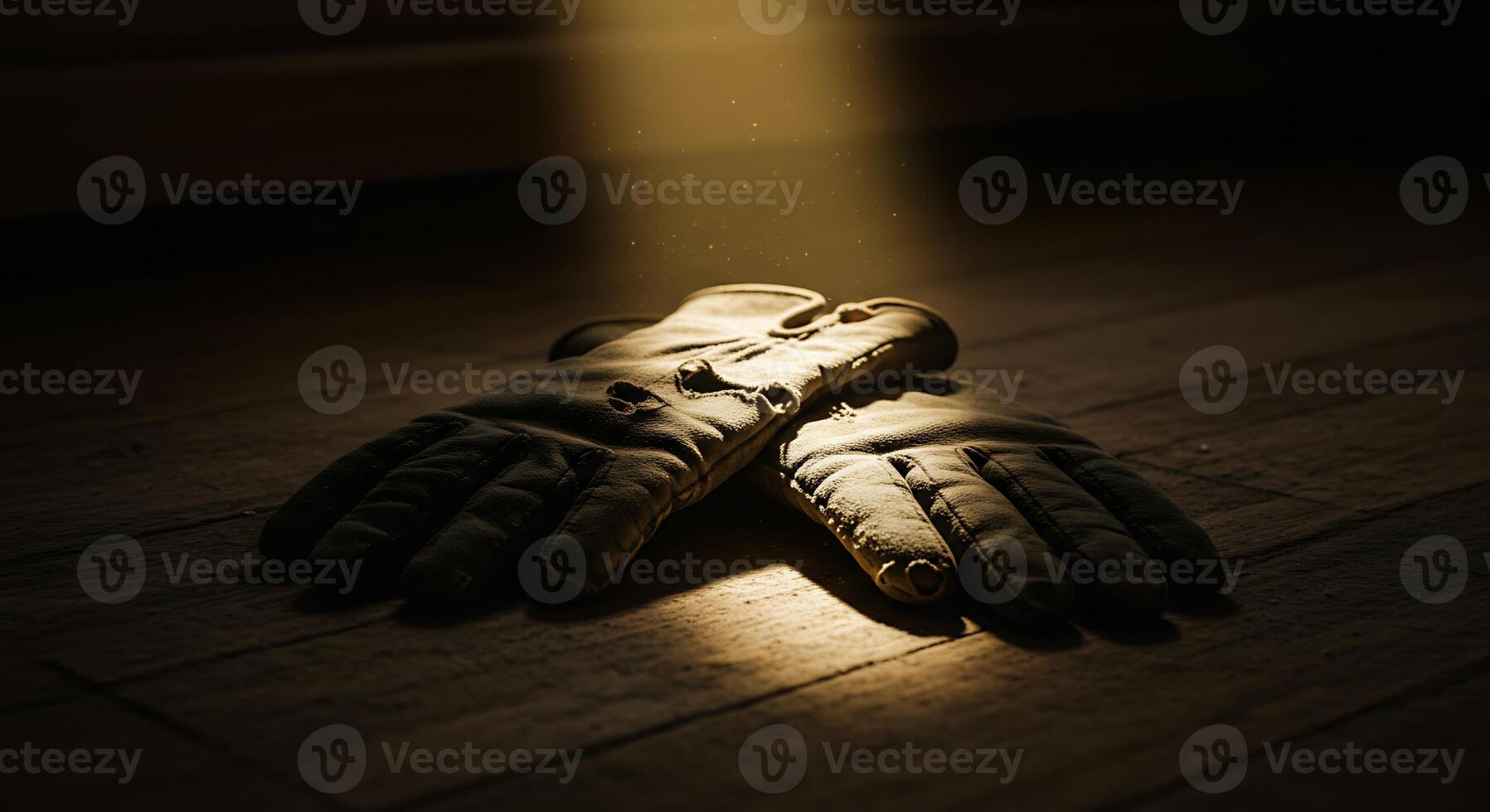 Gloves Lying on a Wooden Surface in a Spot of Light photo
