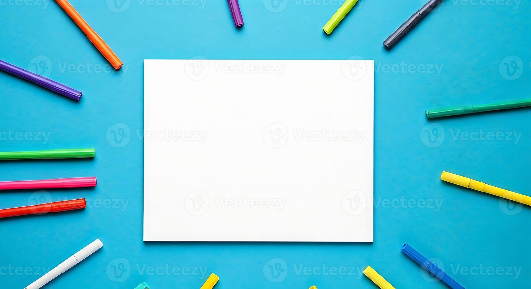 Blank paper with colorful markers on blue background photo