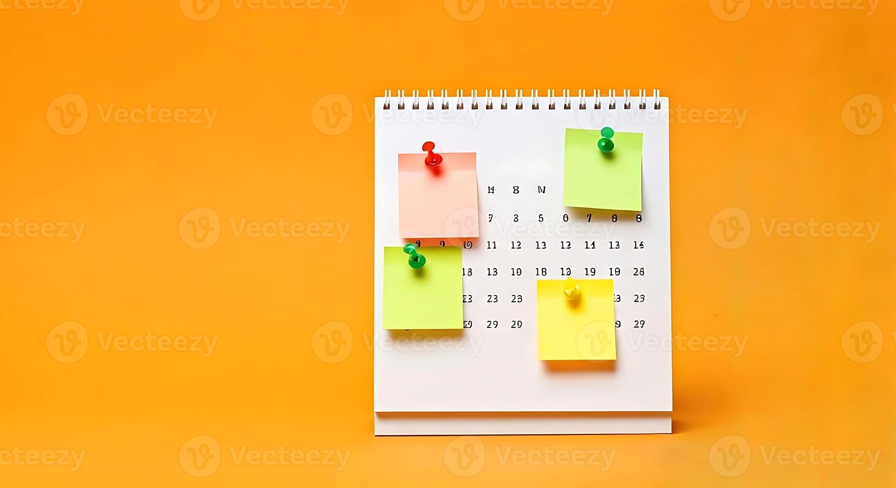 A calendar with sticky notes pinned to it on an orange background photo