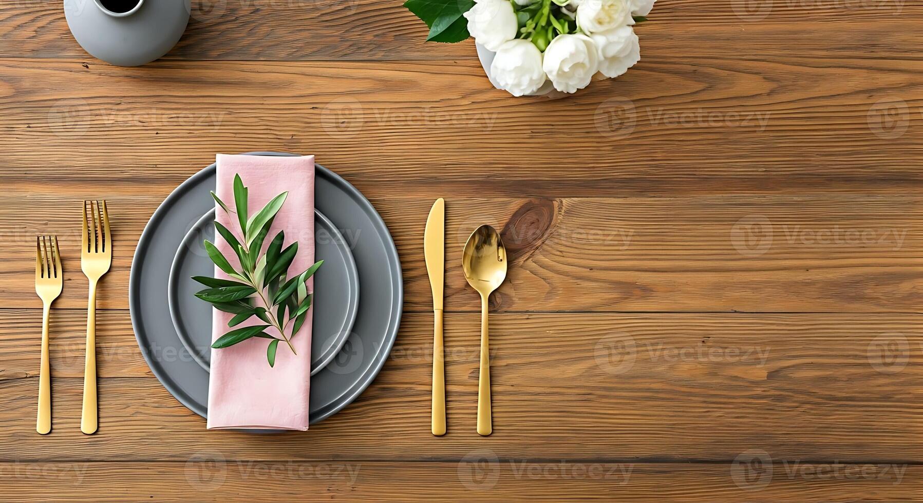 A table with a pink napkin, gold forks and silverware photo