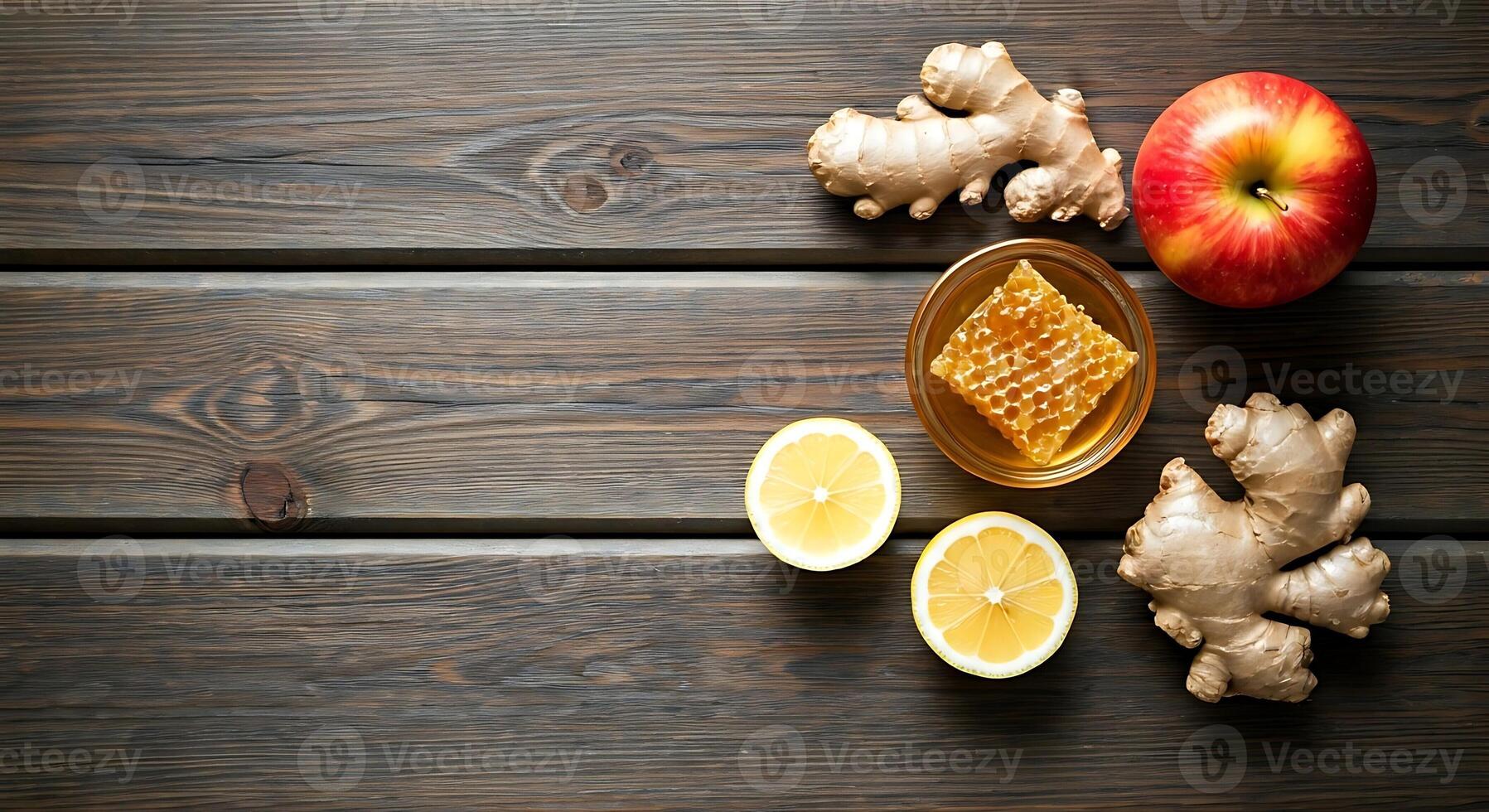 A wooden table with ginger, lemon, honey and apples photo