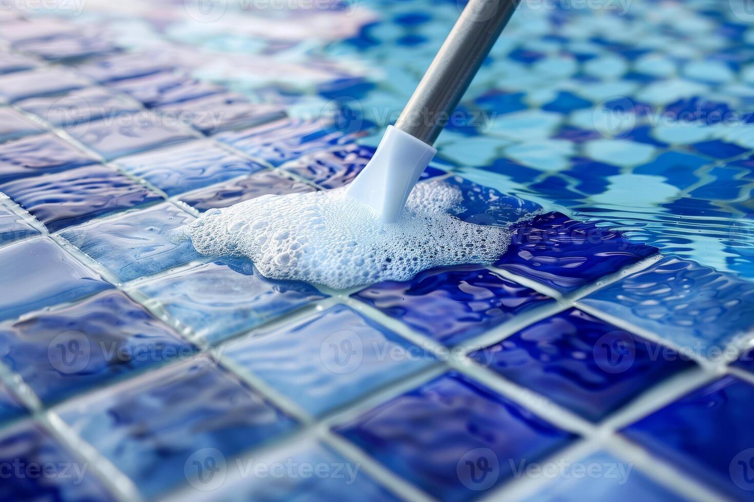 Bubbles rise as a sleek cleaning tool glides over a bright blue mosaic surface in a sunlit pool, showcasing effective cleaning in action photo
