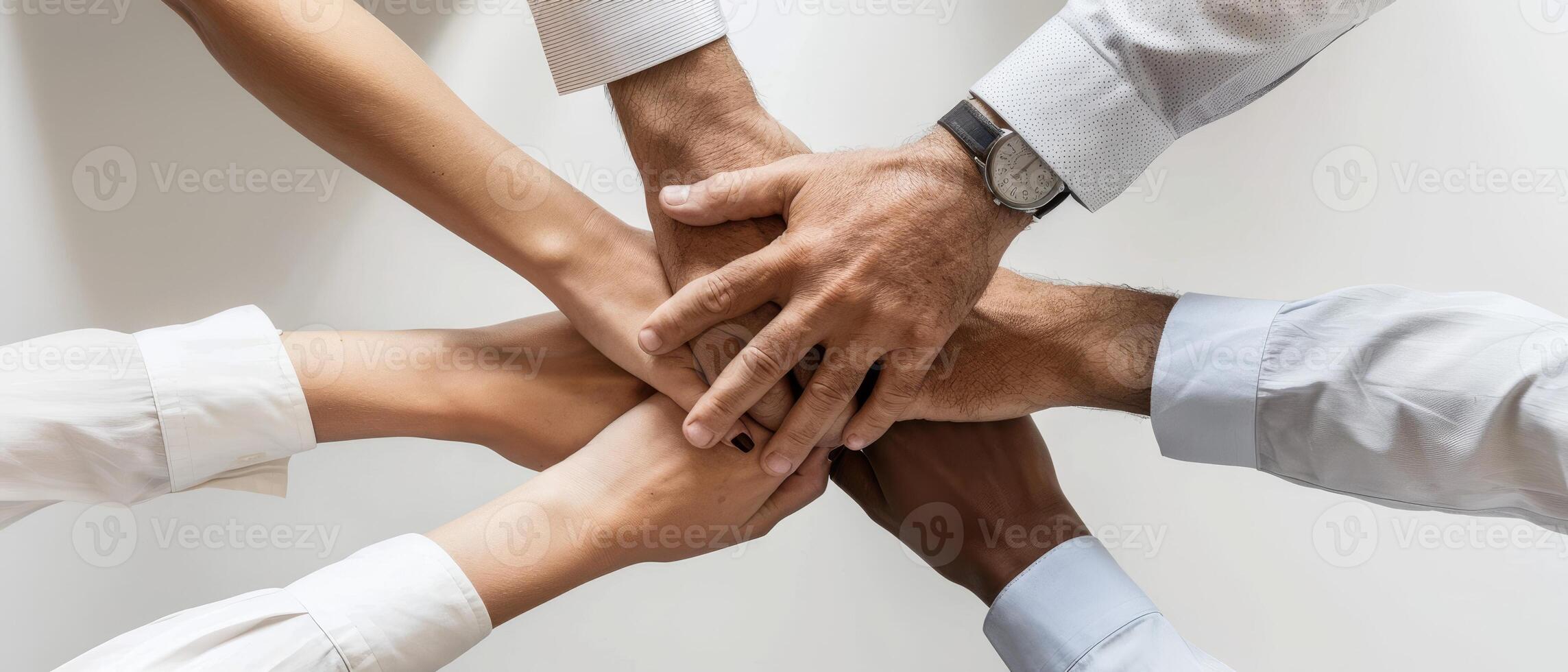 Hands of a diverse team come together in a display of unity and collaboration at a workplace meeting, fostering teamwork and cooperation photo