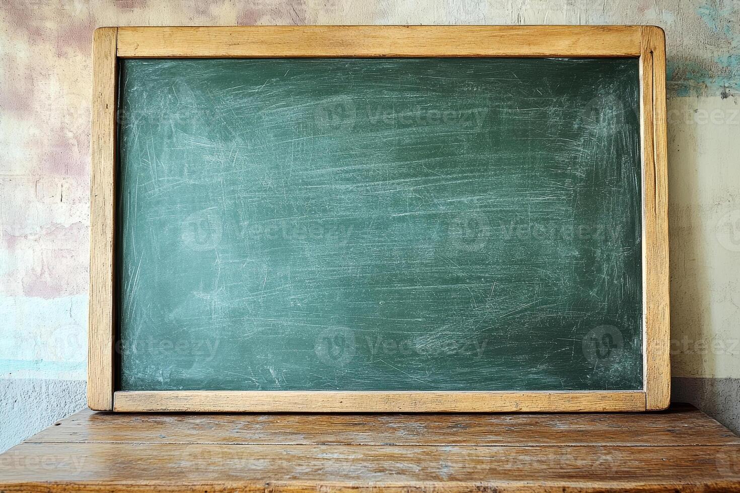 Weathered green chalkboard with a wooden frame sits on a rustic table, showcasing a clean surface ready for writing and teaching photo