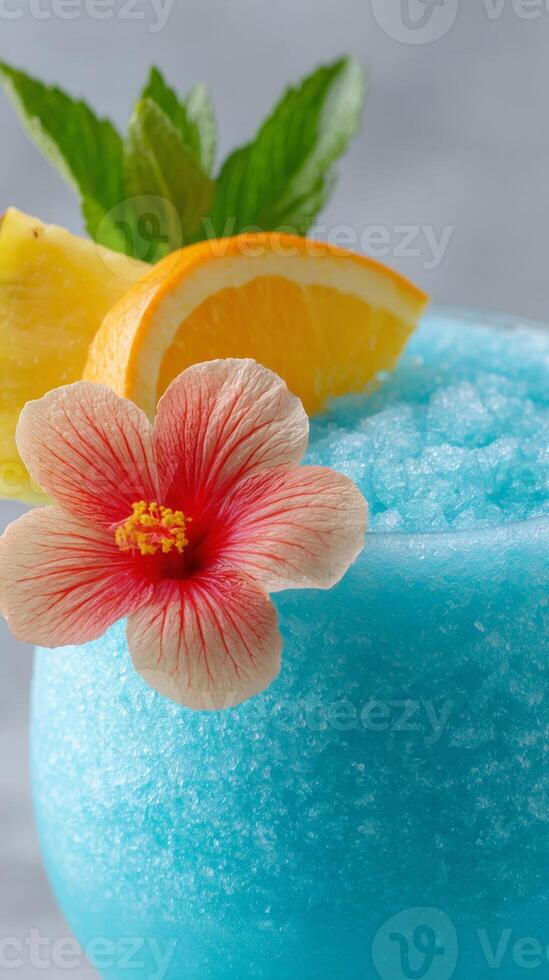Bright blue curacao drink is beautifully garnished with a pink hibiscus flower, lemon wedge, and orange slice, showcasing tropical vibrancy photo