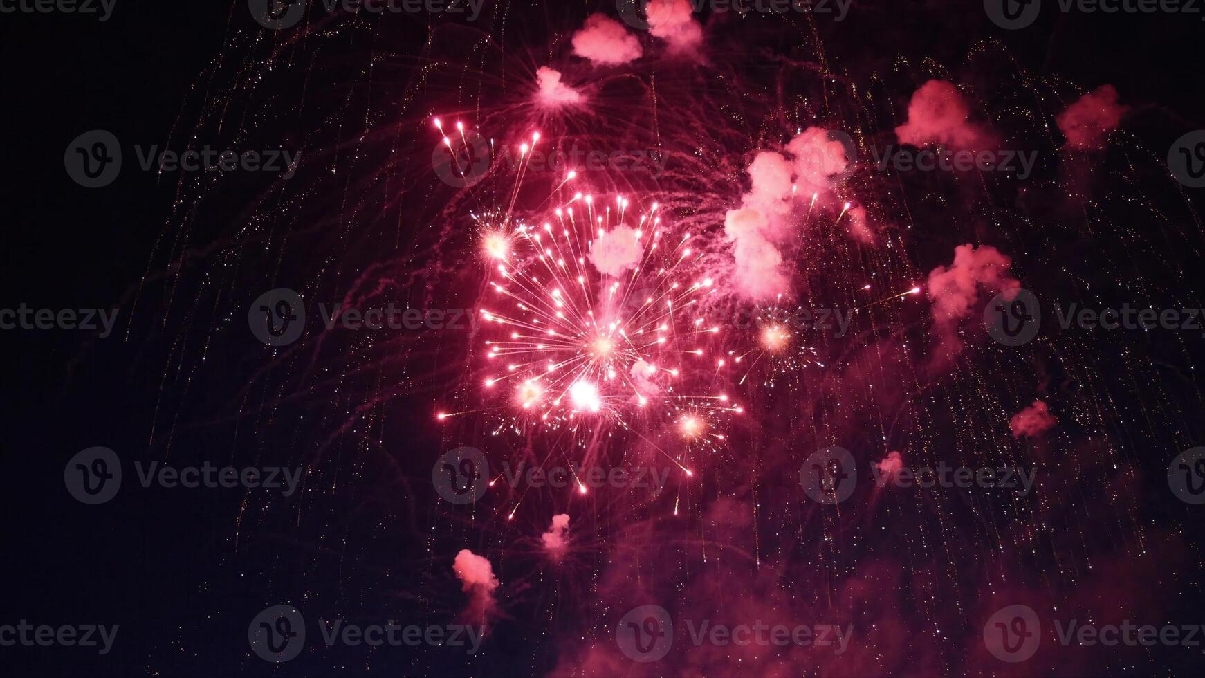 Red fireworks exploding in the night sky during a celebration photo