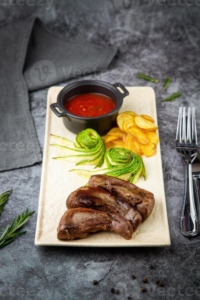 lamb tongues with mashed potatoes and tomato sauce side view photo