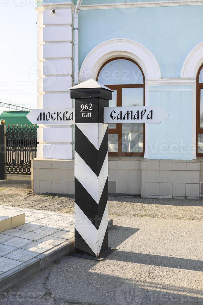 Directional signpost with distance markers for major cities in a vibrant urban setting photo