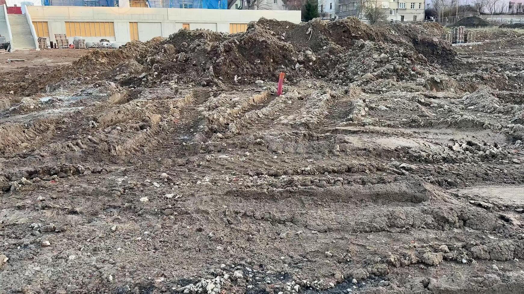The image captures a dynamic view of a construction site featuring uneven and rugged terrain along with earth mounds photo