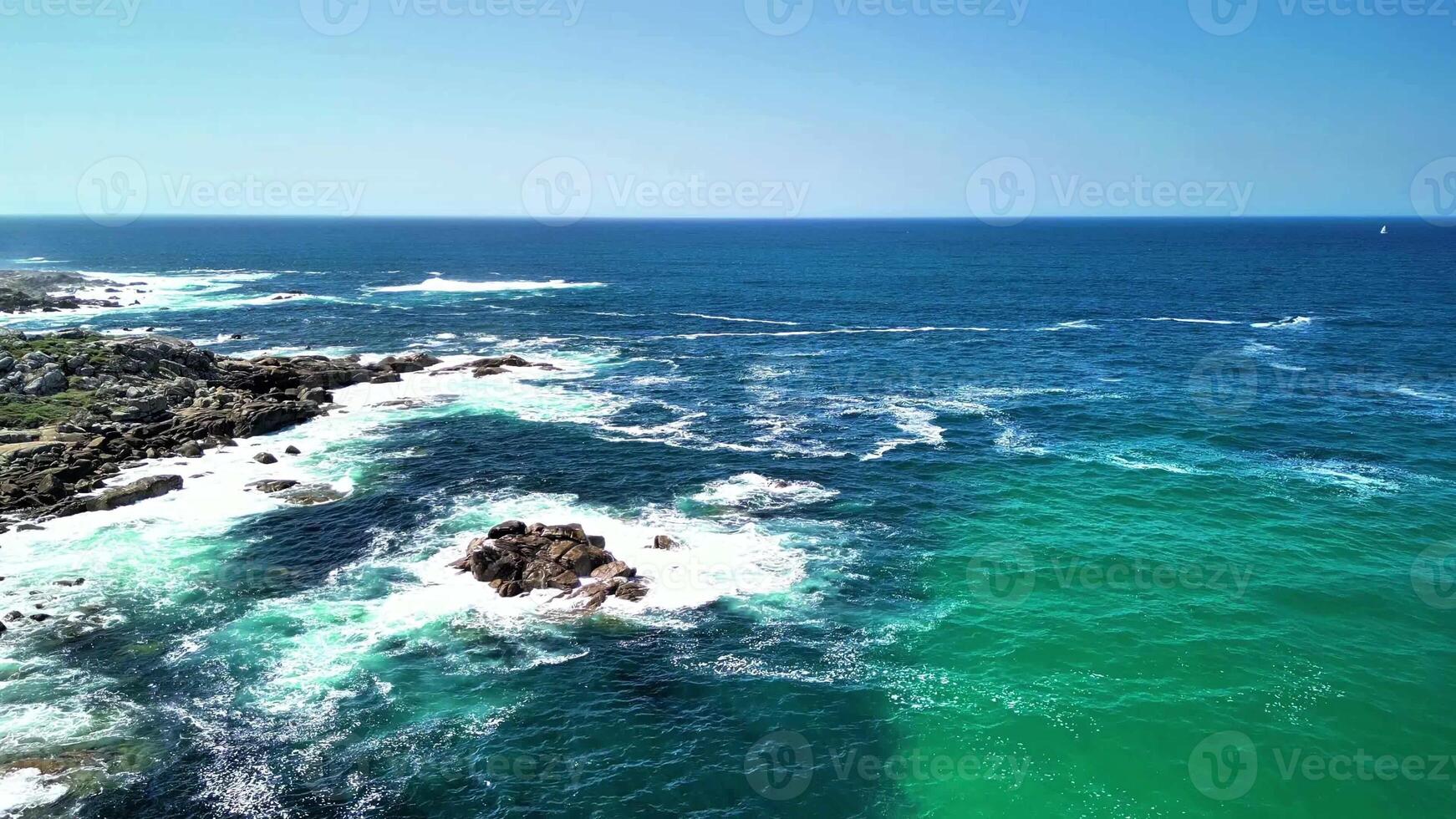 Breathtaking aerial footage captures the beauty of ocean waves crashing against rocks with vibrant color and movement photo