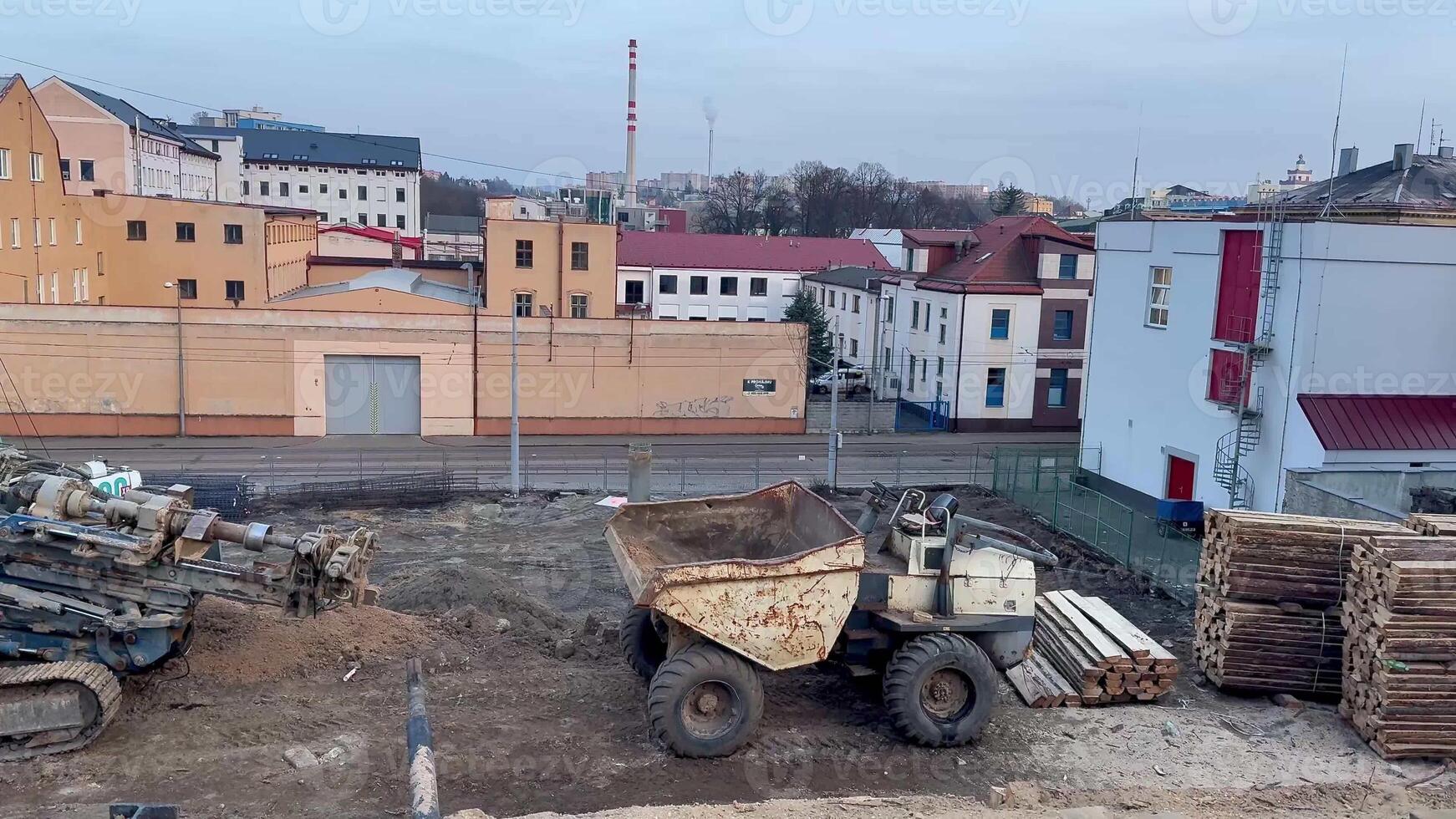 This is a detailed view showcasing a bustling construction site that features heavy machinery and surrounding buildings photo