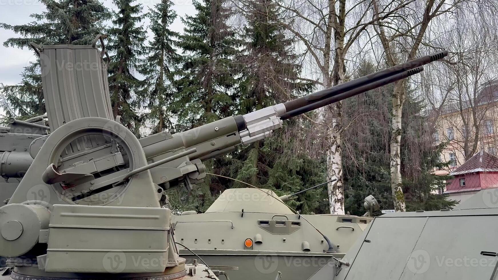 This is a closeup view of a heavy artillery gun that is mounted on a tank, showcasing intricate military engineering photo