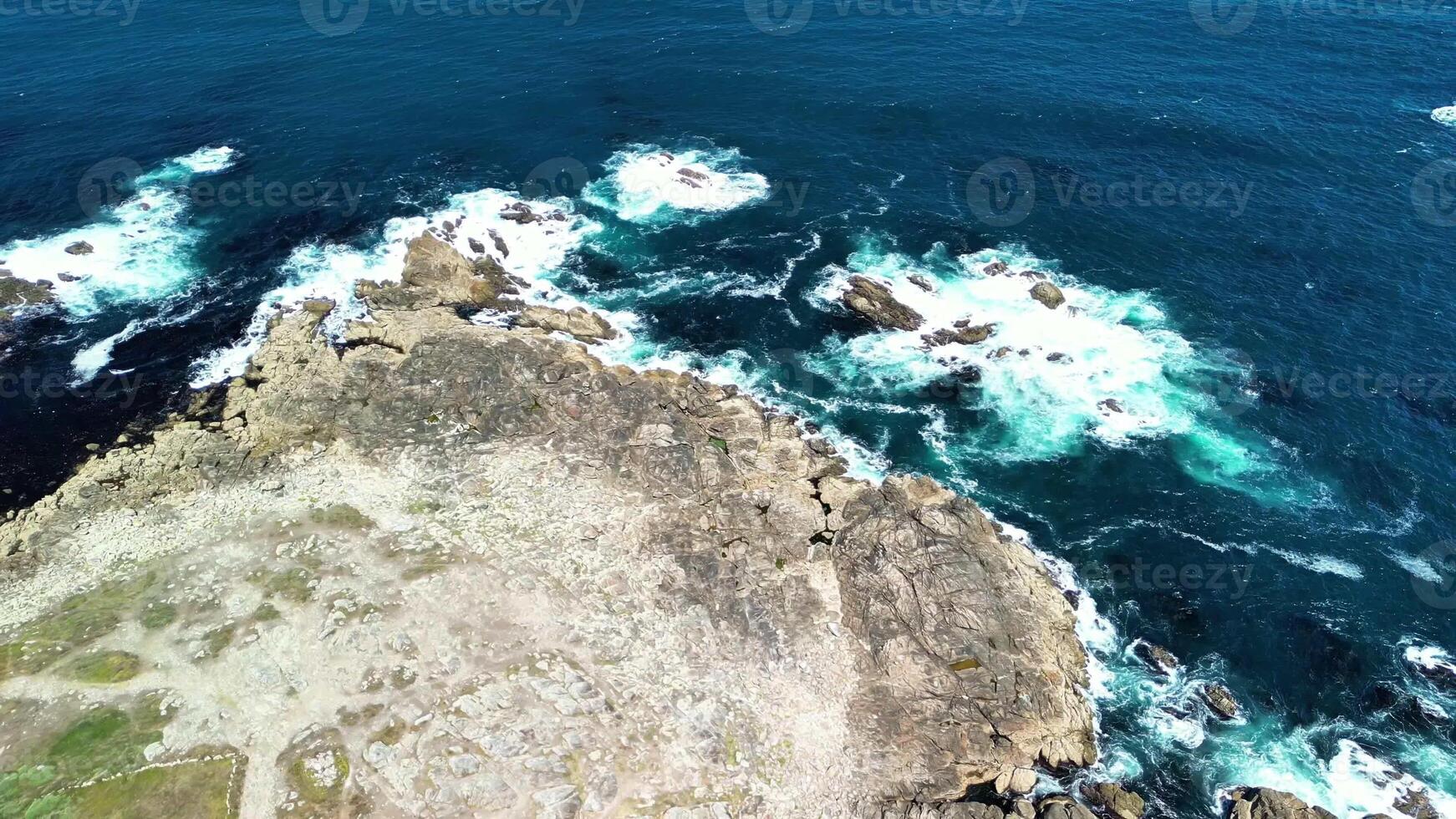 Breathtaking aerial shots capture the stunning rugged coastline with crashing waves and vibrant ocean colors photo