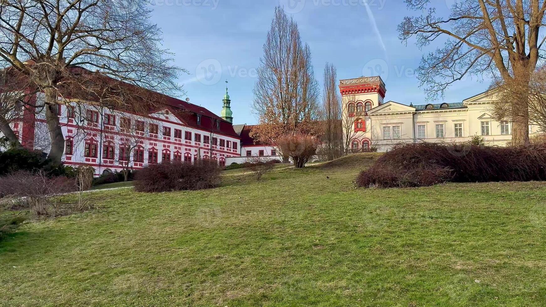 A beautiful scenic view showcases historic buildings set against a lush green landscape under a clear, bright sky photo