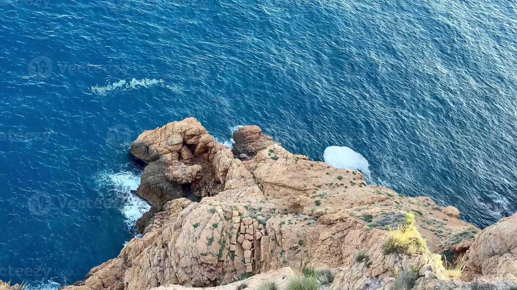Breathtaking ocean scenes featuring waves forcefully crashing against rugged cliffs and relaxing, tranquil waters photo