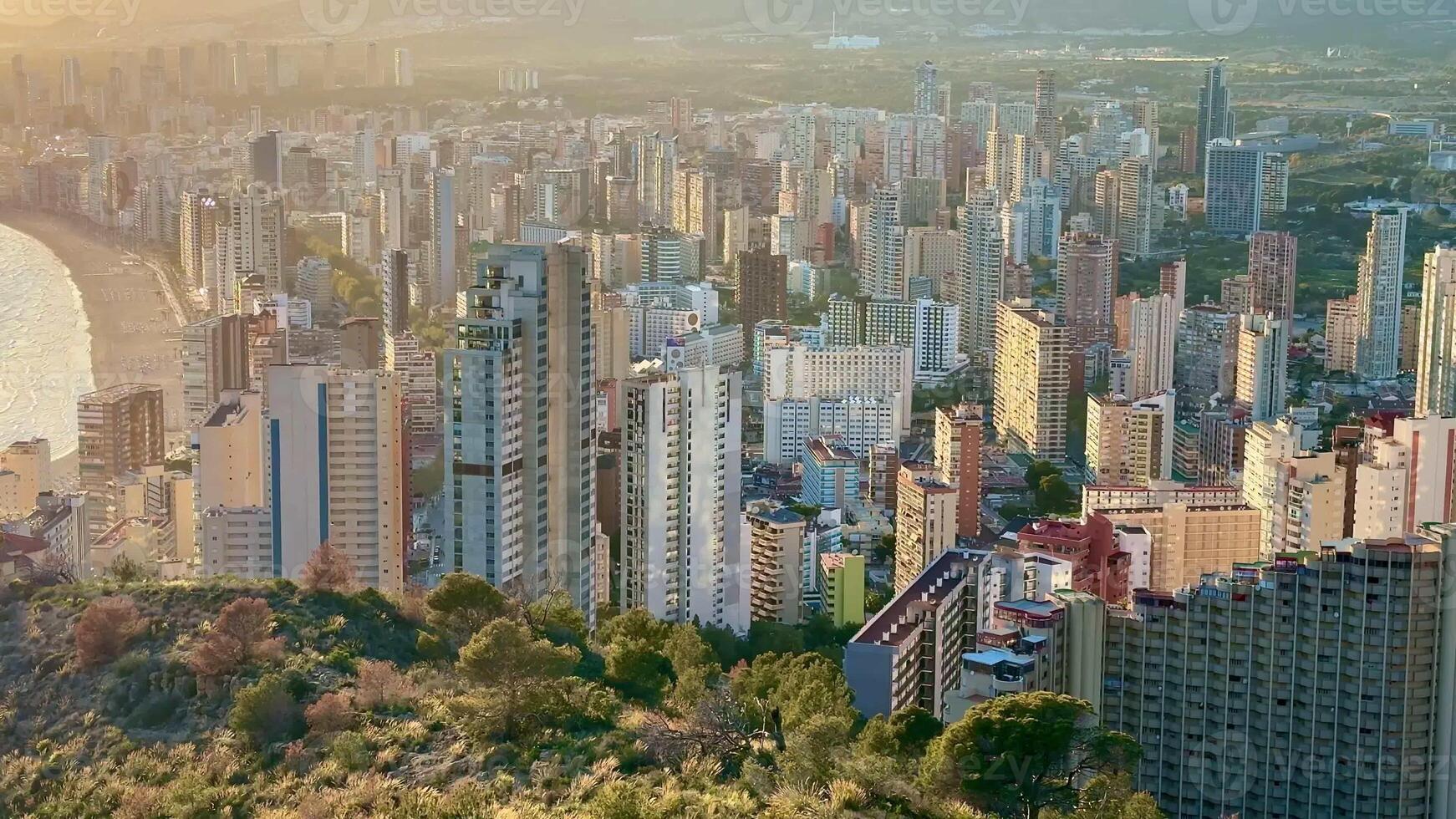 A breathtaking aerial view of the city reveals a stunning skyline and coastline during a picturesque sunset photo