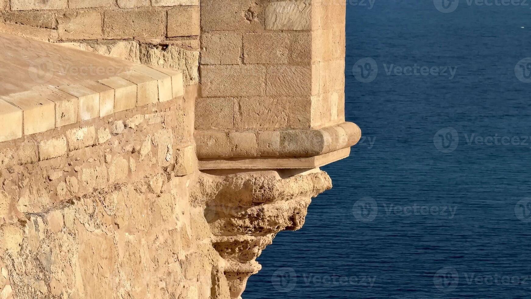 A stunning view of a fortress bastion overlooking the serene ocean, showcasing architectural elegance. photo