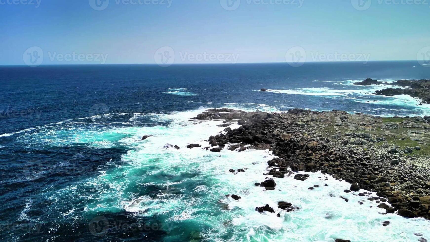 Incredible drone footage captures the stunning sight of vibrant waves dramatically crashing against rugged rocks photo