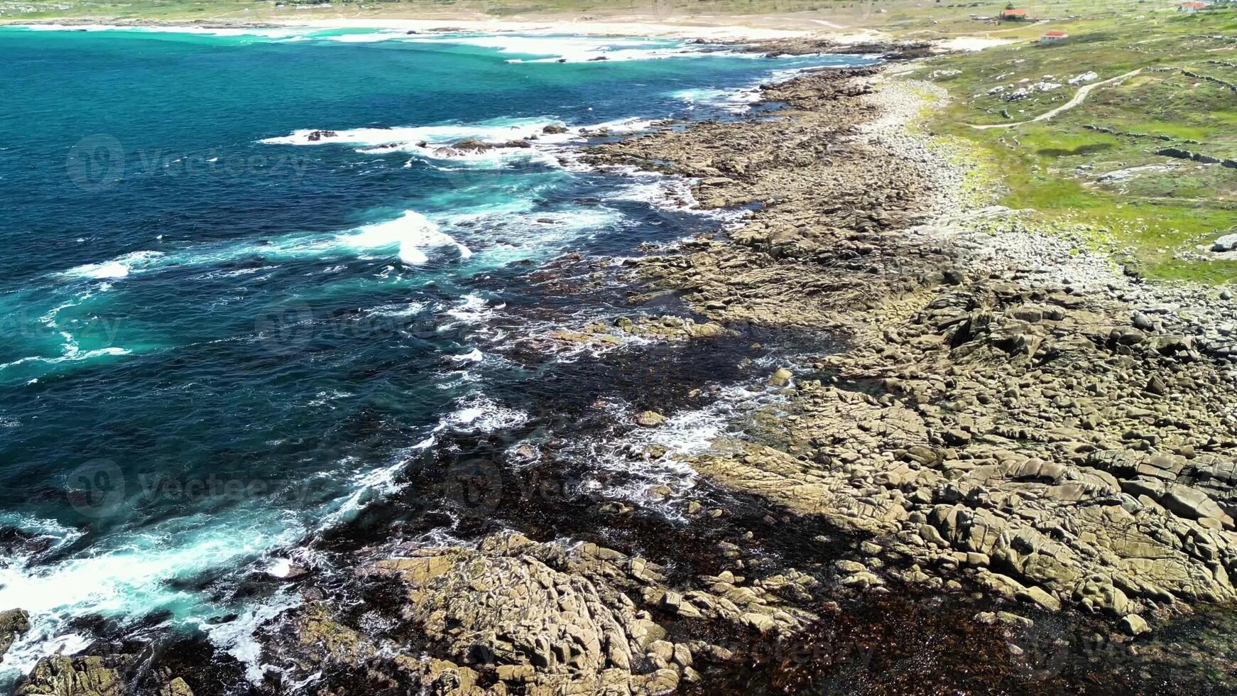 A stunning coastal view of rocky shorelines and vibrant blue waters glistening under bright sunlight photo