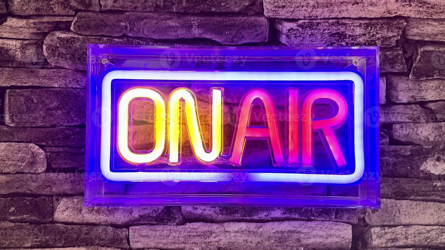 A bright neon sign that prominently says ON AIR, ideal for studios, media setups, and creative spaces photo