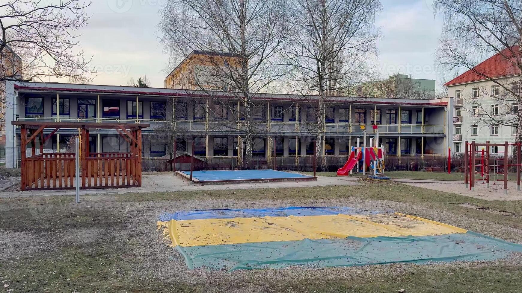 Outdoor playground featuring equipment and grass area beside a school, perfect for children's activities. photo