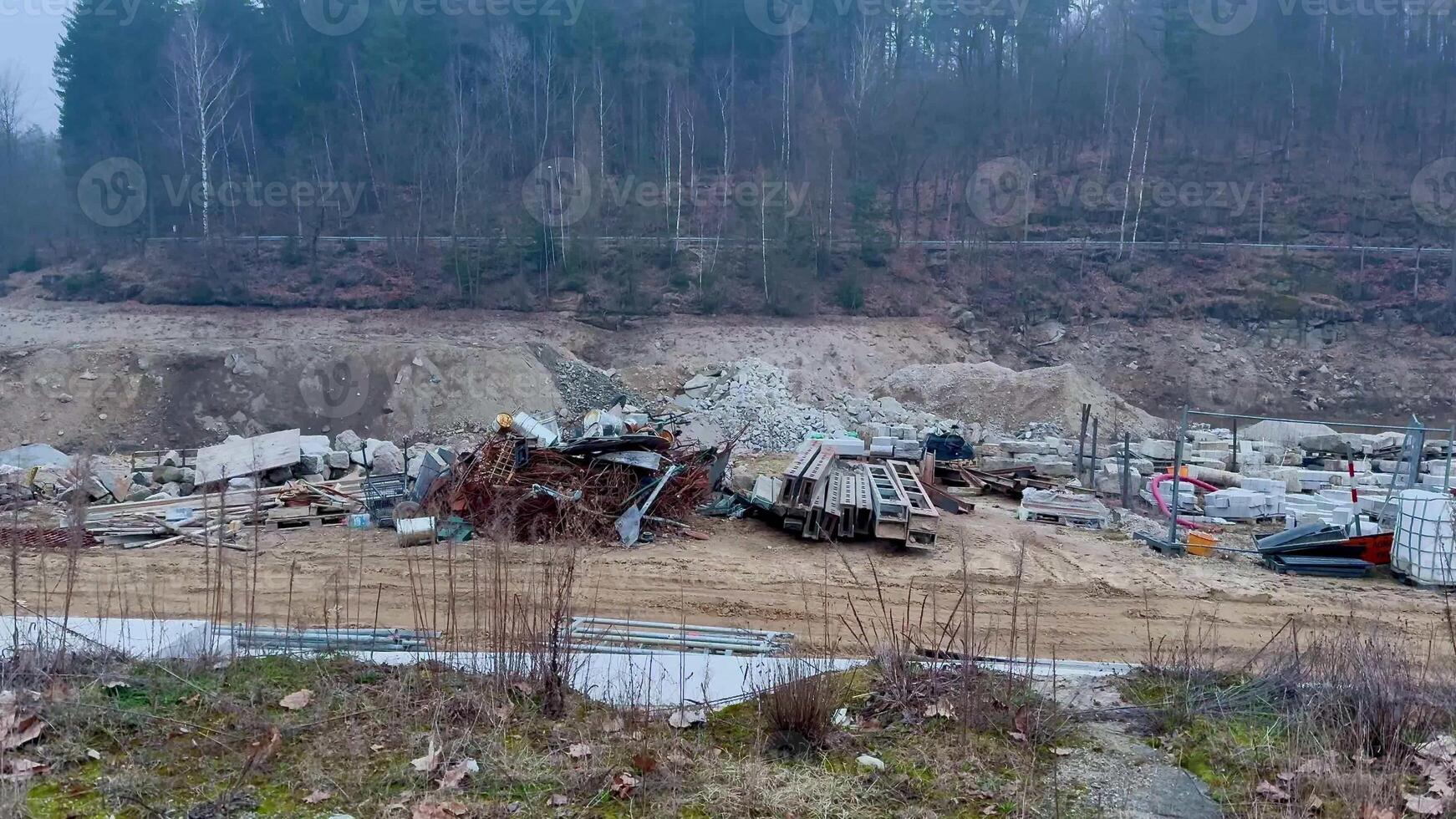 A desolate and haunting scene of wreckage, with abandoned vehicles littered throughout a construction site in nature photo