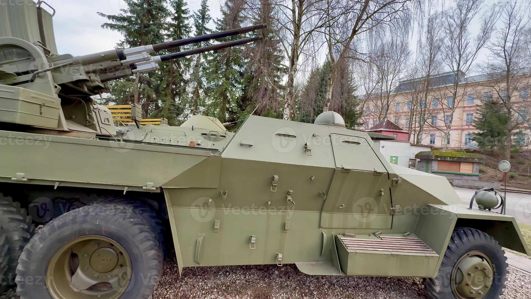 An intricately detailed view of a green military vehicle showcased prominently in a lush park setting photo