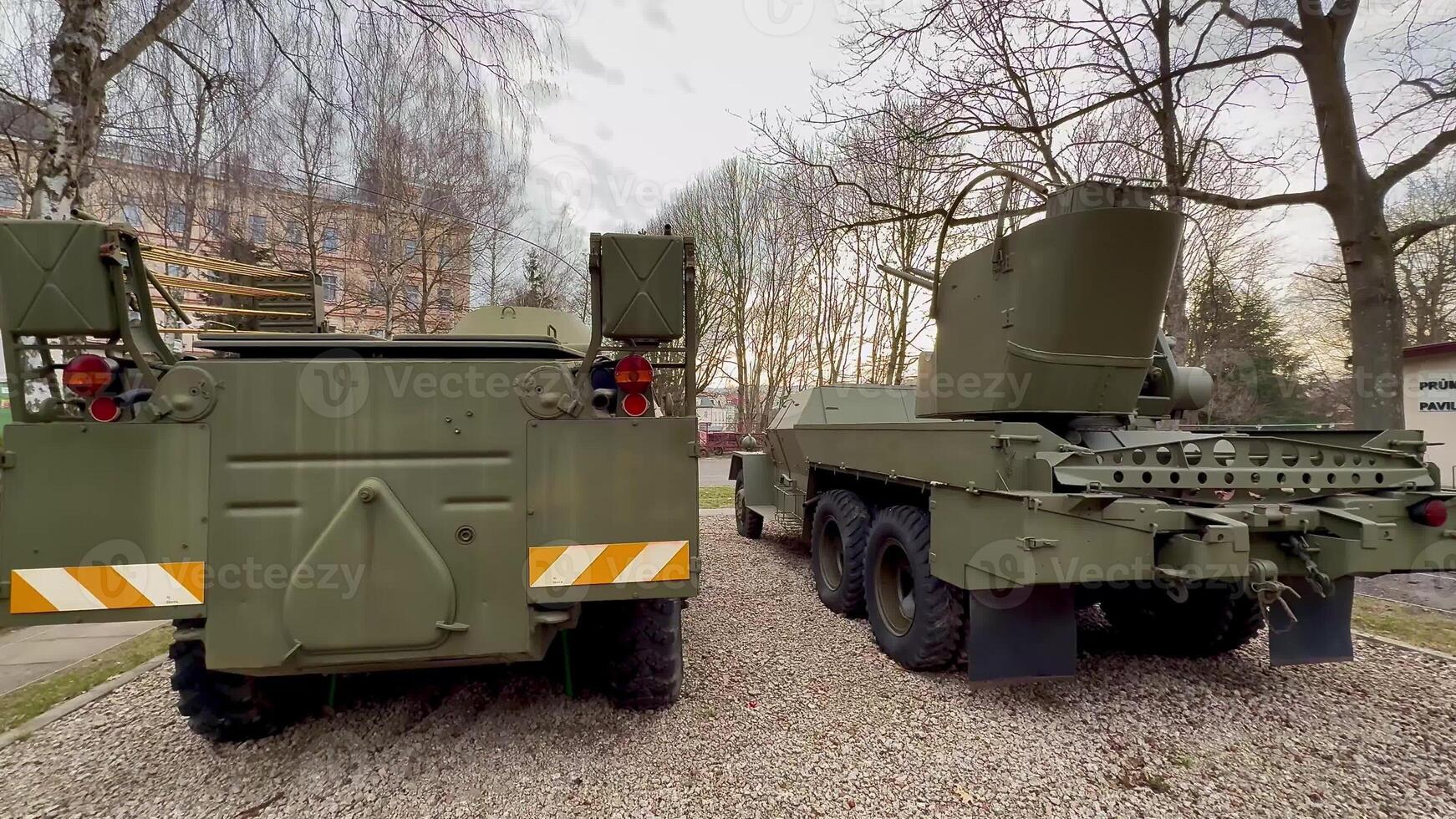 Two military vehicles are parked closely together, showcasing their impressive tactical design and functionality photo