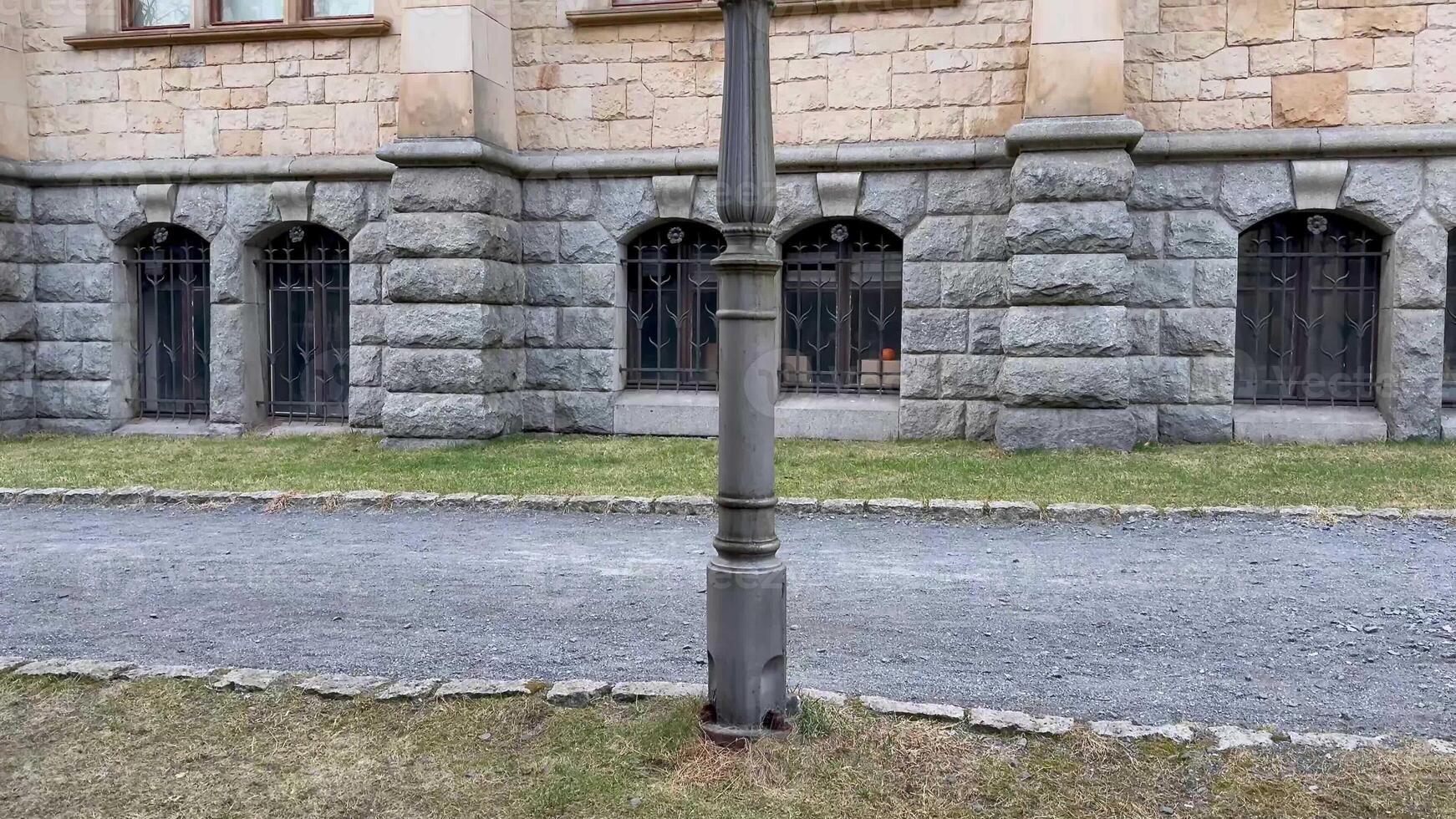 A street scene featuring a vintage lamp post with stunning historic stone architecture in the background photo