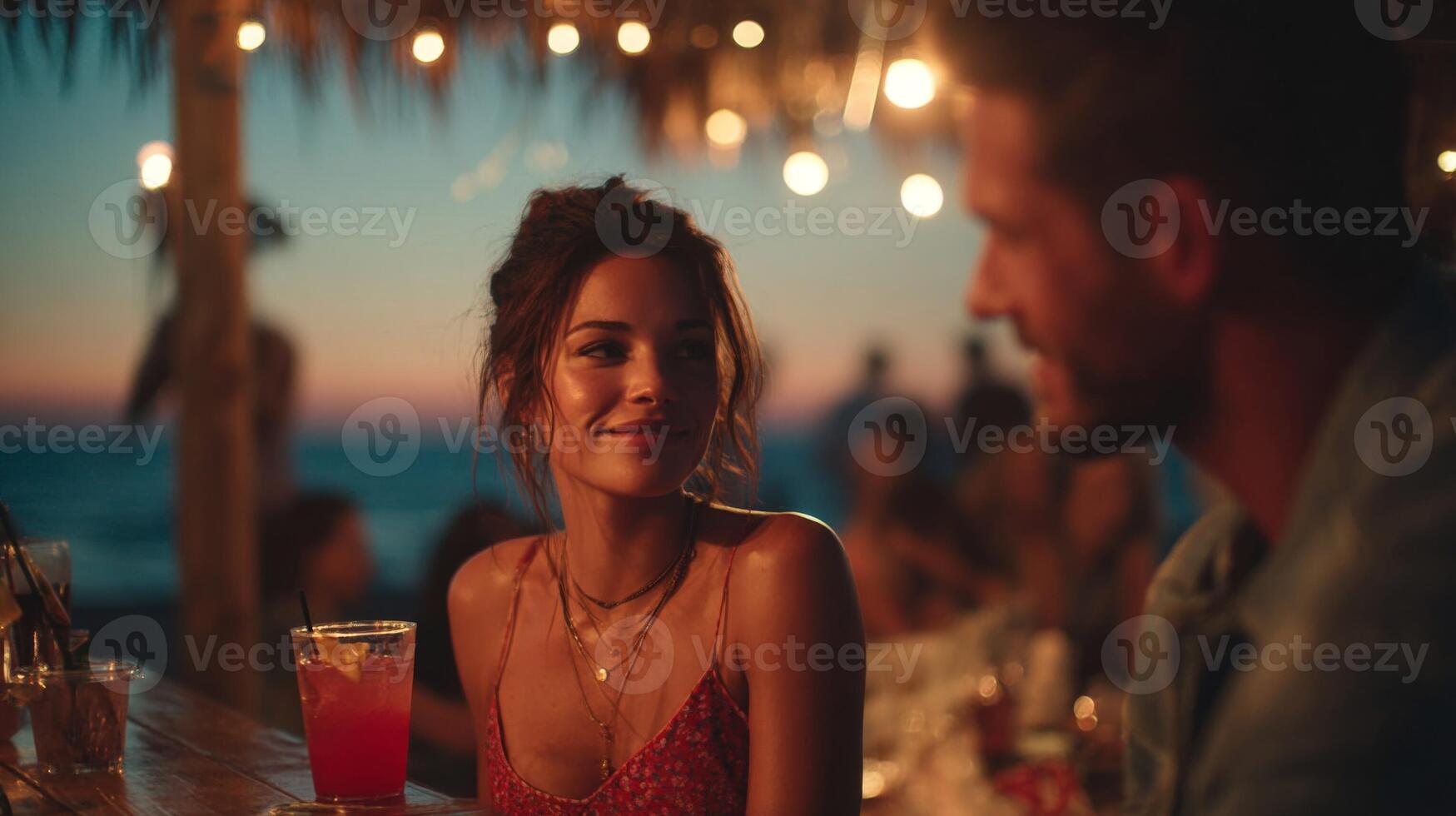 Romantic Couple Enjoying Drinks at a Beach Bar at Sunset photo