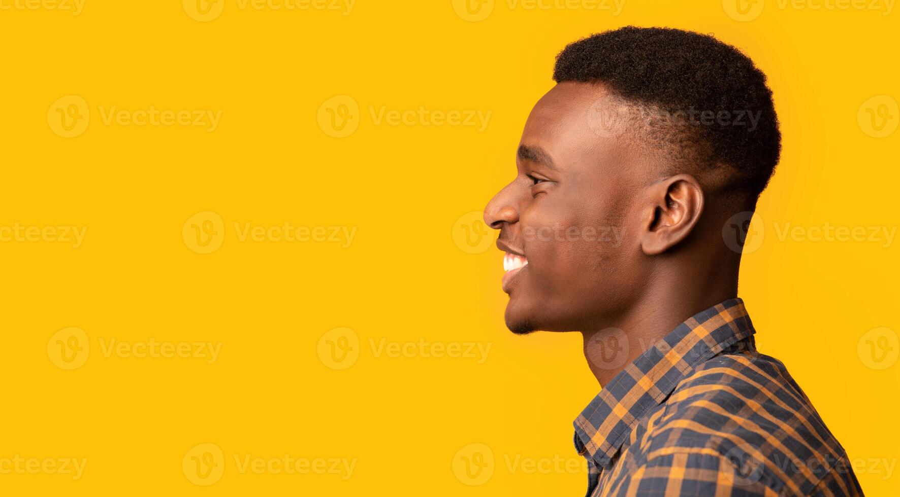 Profile Shot Of Cheerful Young African American Guy Looking Aside At Copy Space, Side View Of Positive Black Millennial Man In Checkered Shirt Standing Isolated On Yellow Background, Panorama photo