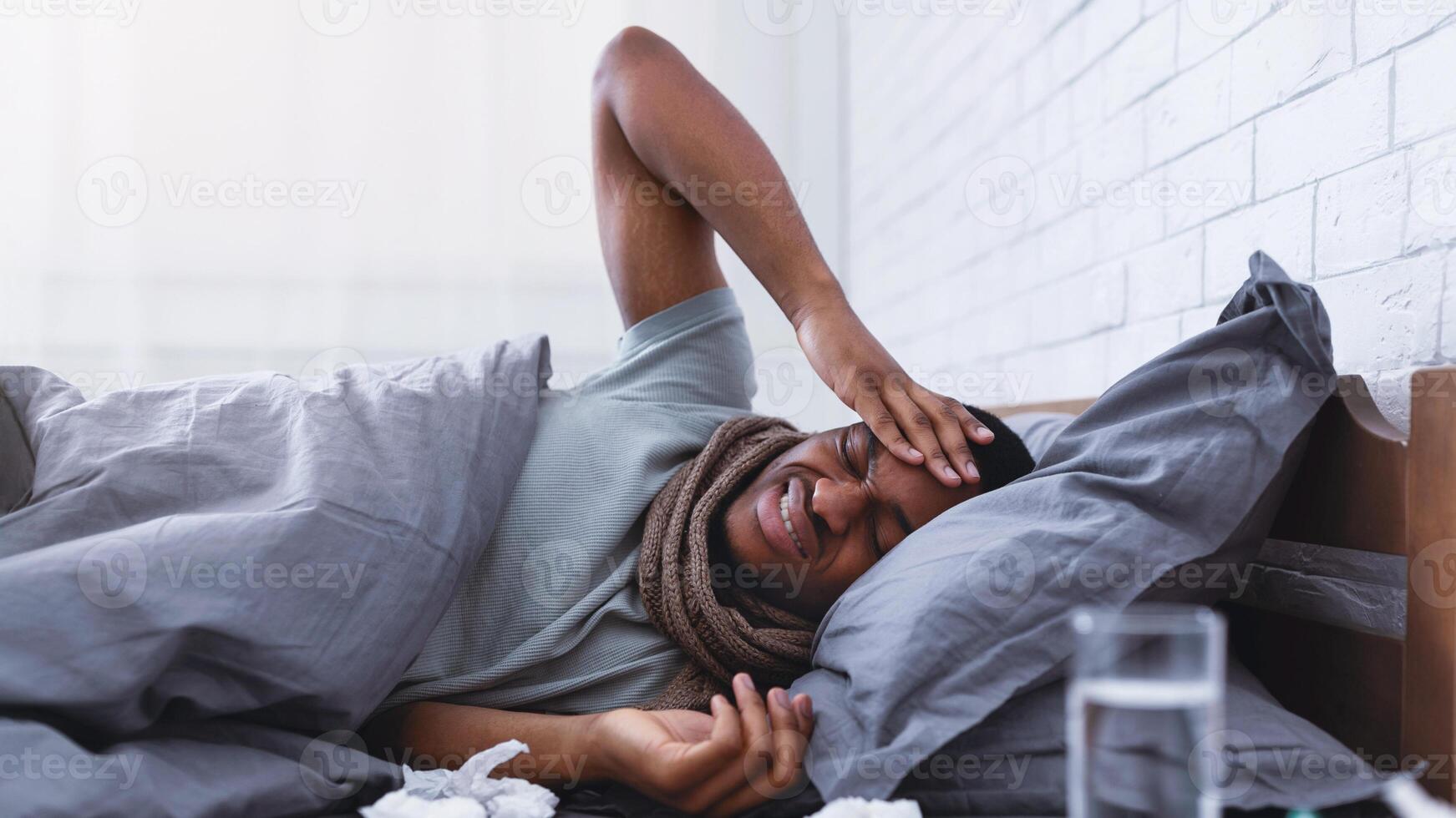 Ill African American Guy Having Severe Headache Suffering From Pain Touching Aching Head Lying In Bed At Home. Migraine During Influenza And Cold Concept. Selective Focus photo