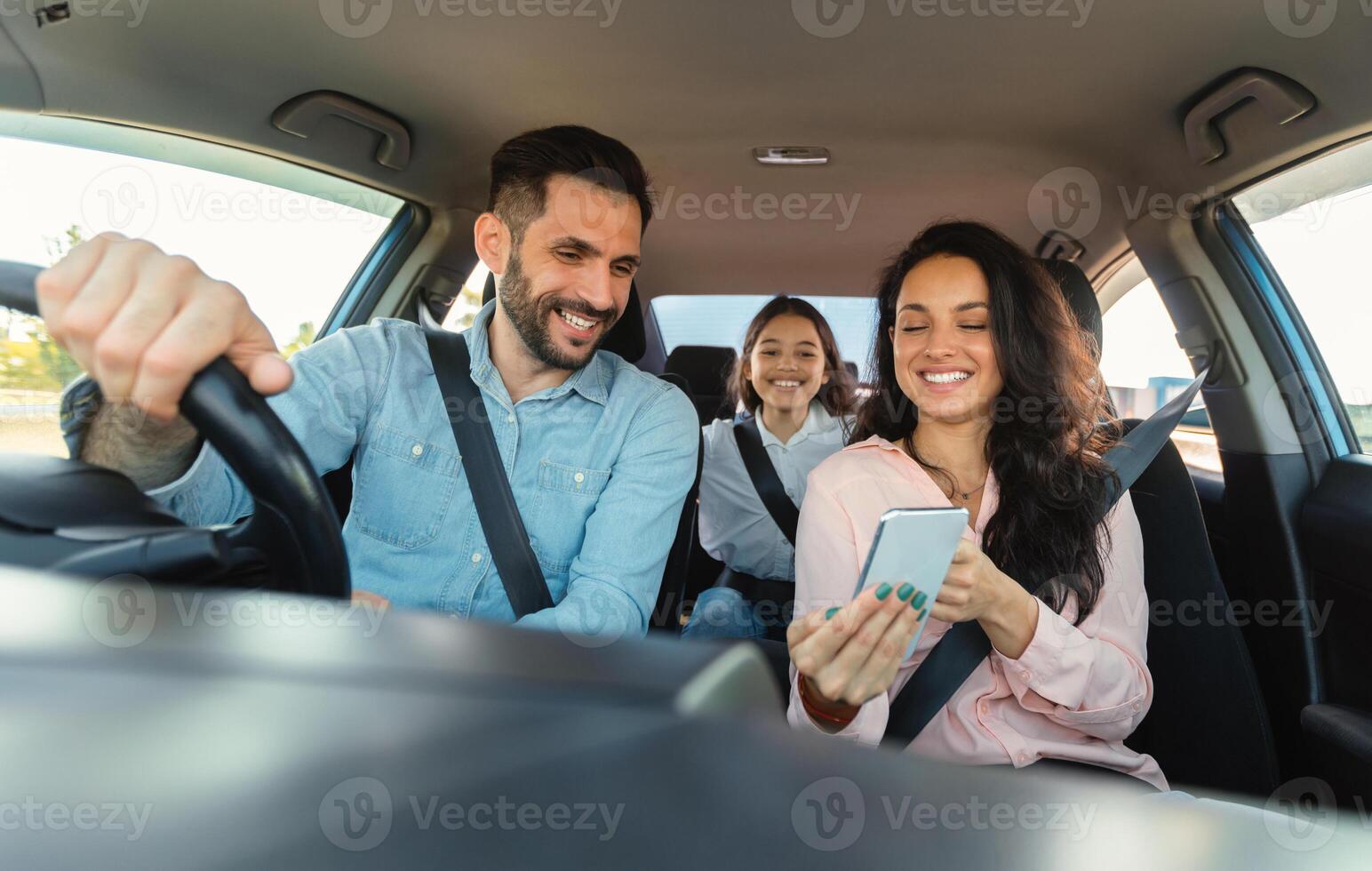Car navigation app. Happy woman showing gps application on cellphone to driver man, family travelling and navigating vehicle with gadget, enjoying weekend trip photo