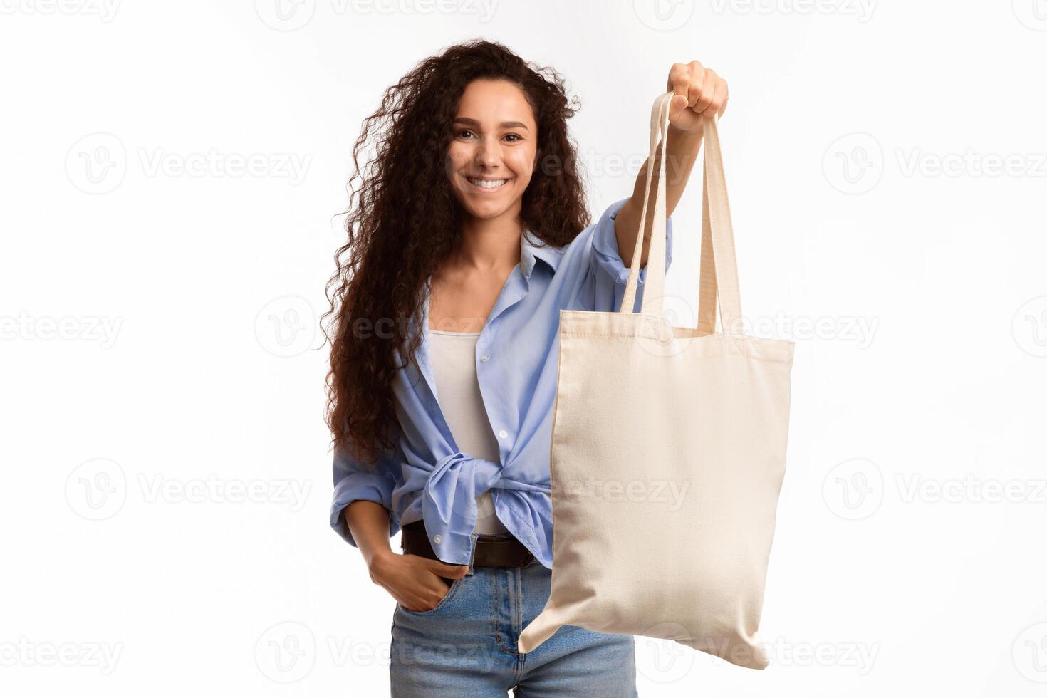 Use Eco Bag. Joyful Young Female Showing White Textile Shopper Handbag Smiling To Camera Standing In Studio Over White Background. Minimalism And Eco-Friendly Lifestyle photo