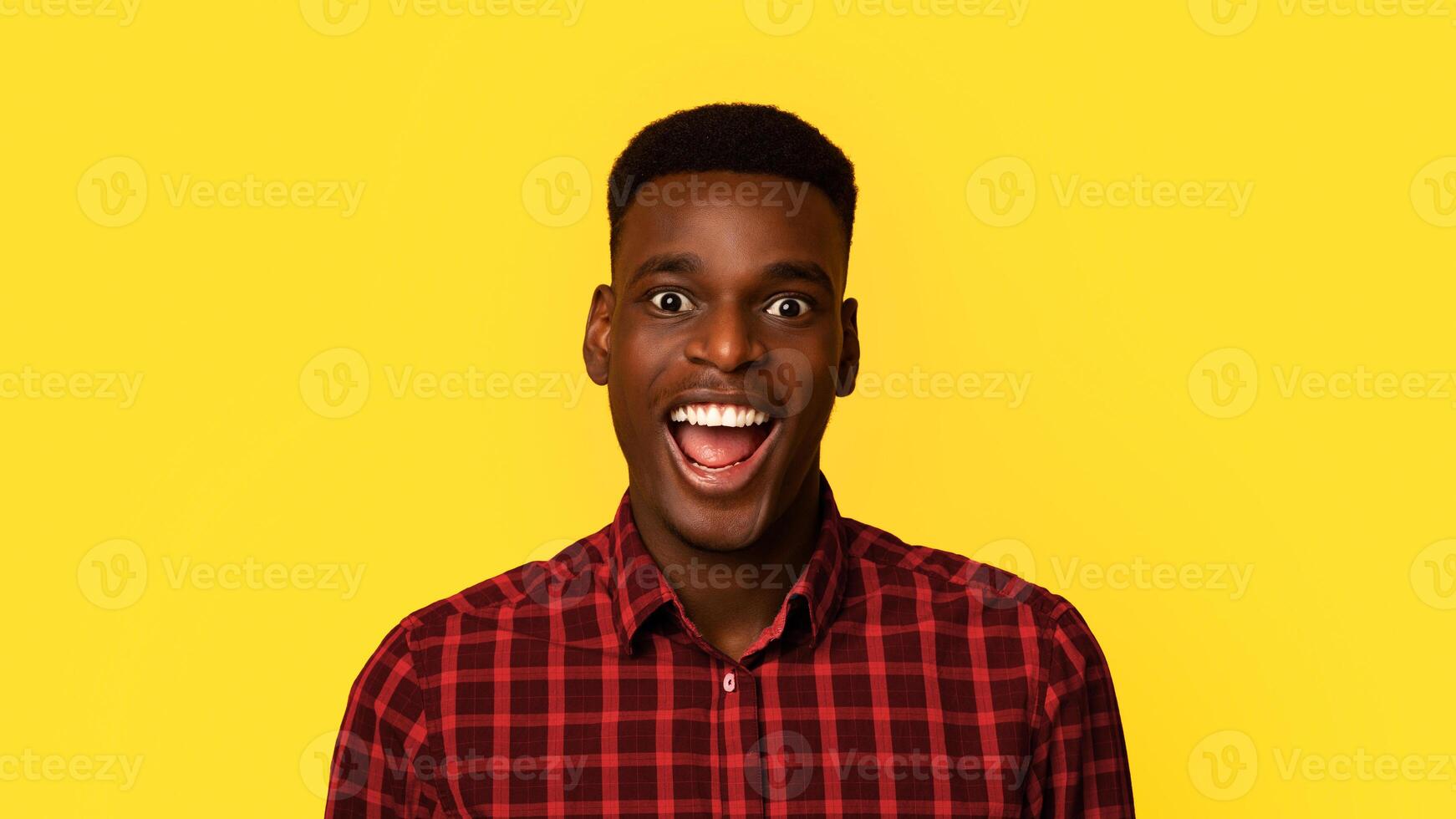 Closeup Portrait Of Excited African American Guy Looking At Camera With Amazement, Surprised Black Millennial Man Standing With Opened Mouth Over Yellow Background, Closeup Shot With Copy Space photo