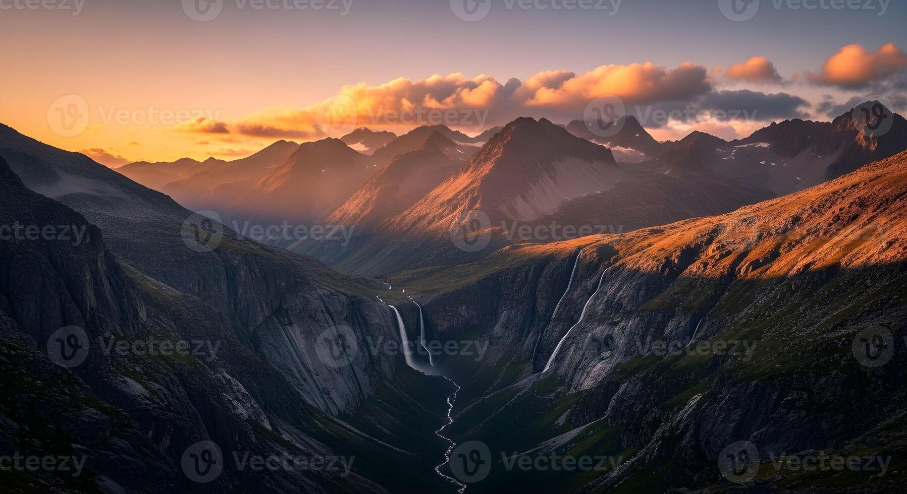 Sunset Over Rugged Mountain Valley with Waterfalls and Dramatic Sky photo