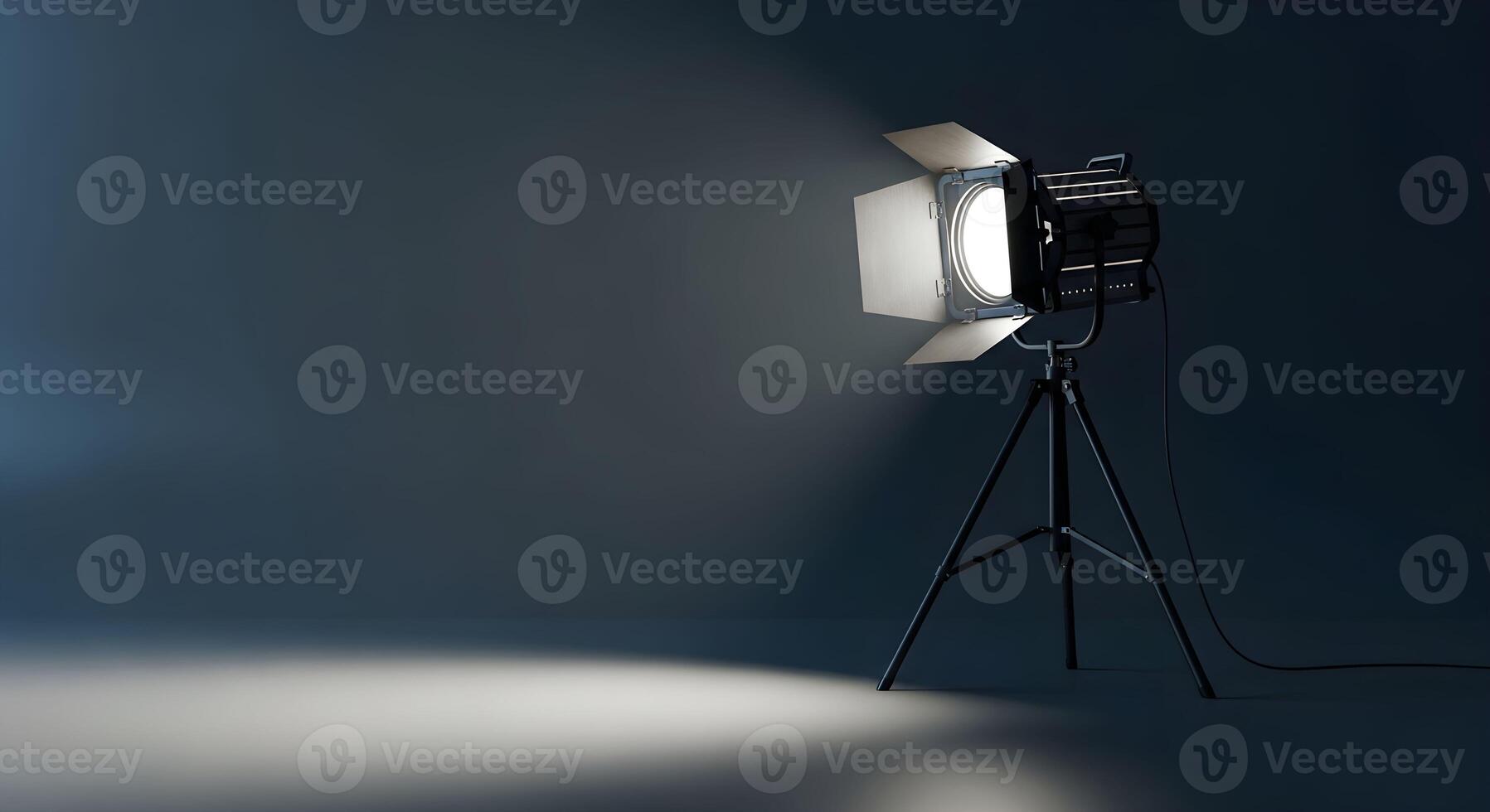 A minimalist, high-contrast image featuring an empty dark studio space with a single professional studio light mounted on a black tripod photo