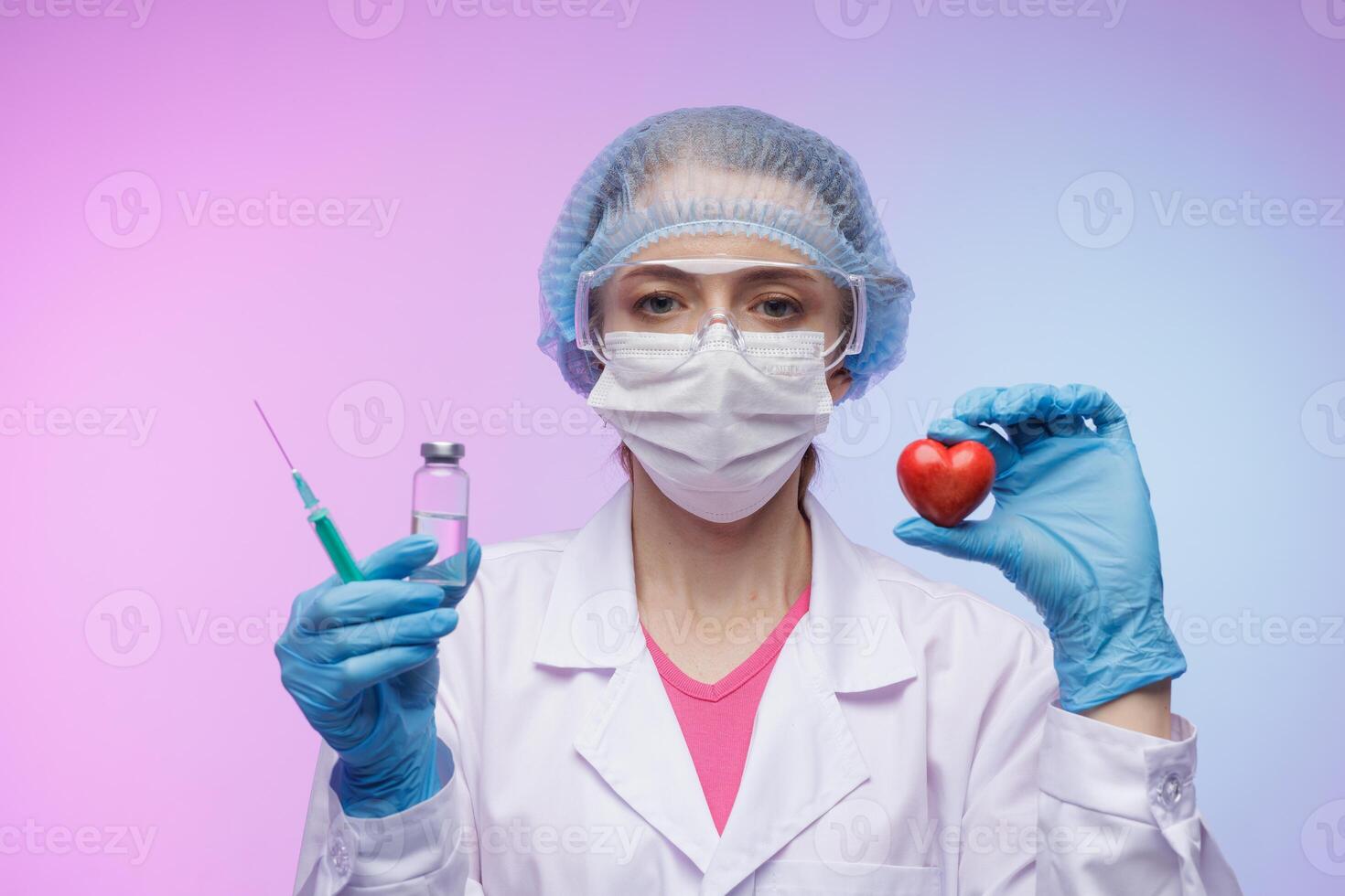 Female doctor in protective medical gear holding a syringe, vaccine vial, and red heart symbol, representing healthcare, immunization, and love for human life on colorful gradient background. photo