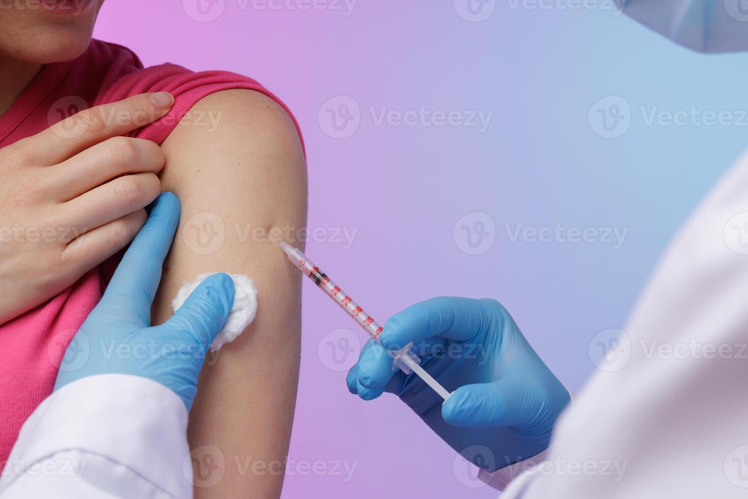 Close up of a healthcare worker administering a vaccine injection into a patient upper arm, symbolizing protection, medical care, and immunization against viruses. photo