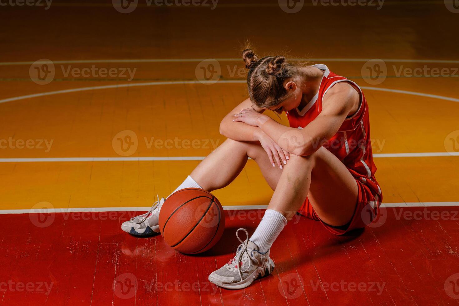Dejected Female Basketball Player on Court photo