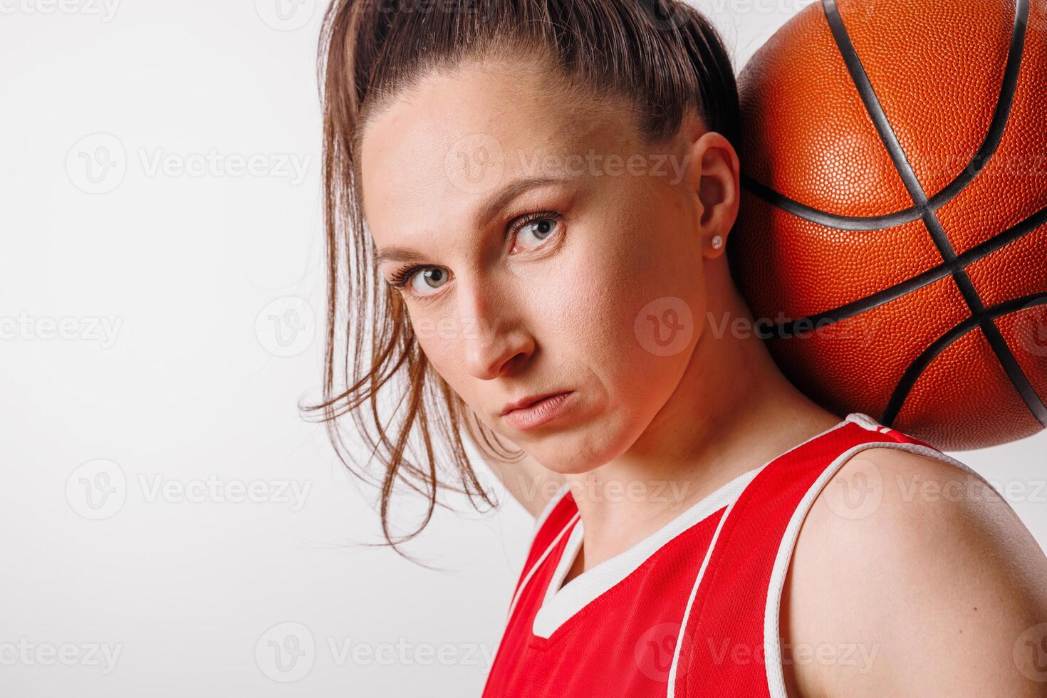 Determined Female Basketball Player in Red Jersey with Ball, Focused Athletic Portrait on White photo
