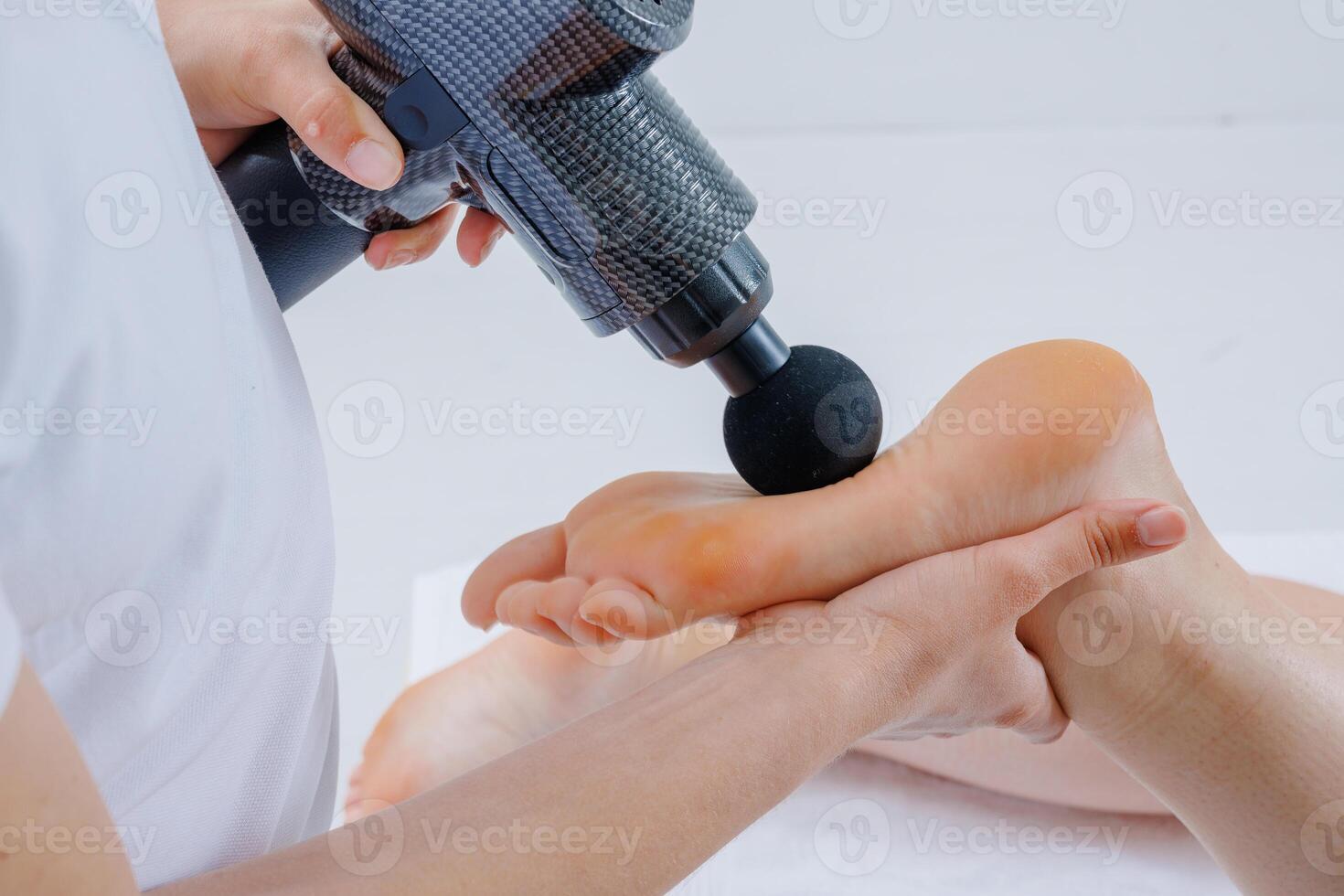 Closeup of Foot Massage Using Percussion Therapy Gun for Pain Relief and Muscle Stimulation photo